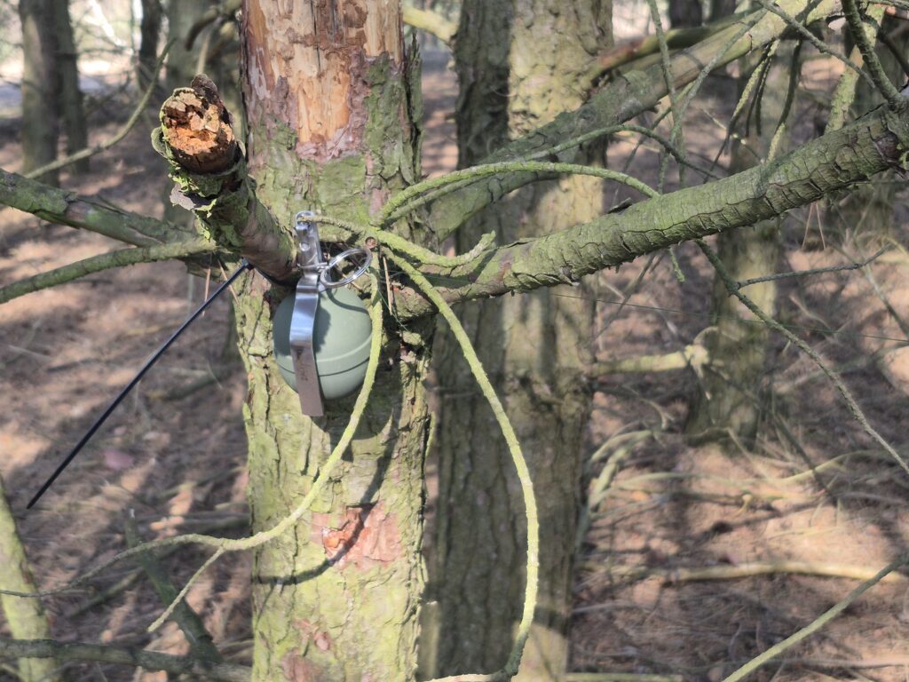 Granat-pułapka zawieszony na drzewie