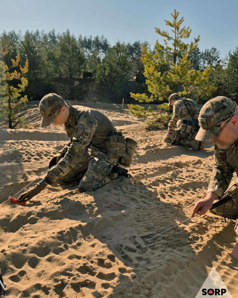 Uczestnicy szkolenia szukają min przy użyciu macki saperskiej